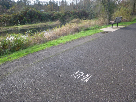 Example of distances marked on the Salmon Creek Greenway Trail – hard surface – bench – pond